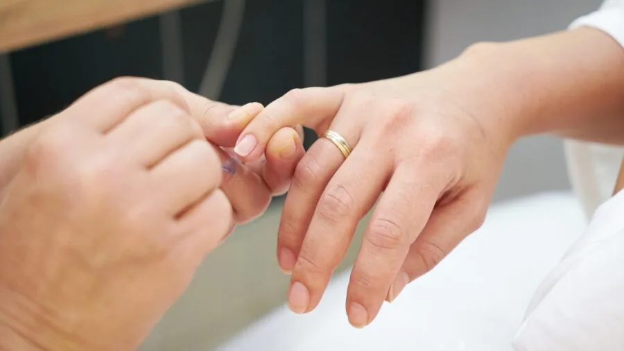 Woman filing and buffing nails with focused attention to nail care and grooming