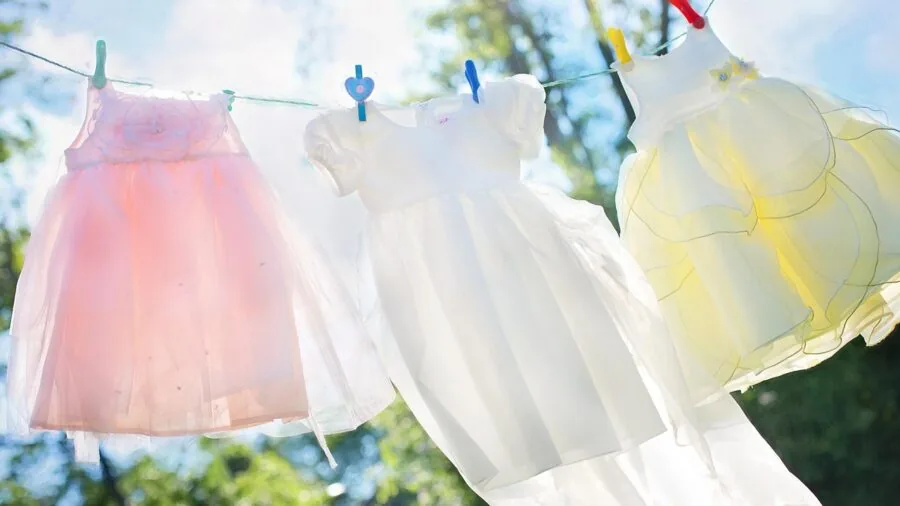 Woman folding clean laundry after washing, demonstrating proper garment care and durability