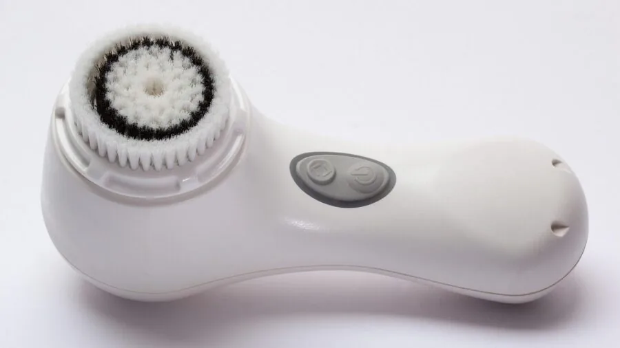 Woman gently misting face with skincare product, demonstrating sensitive skincare routine