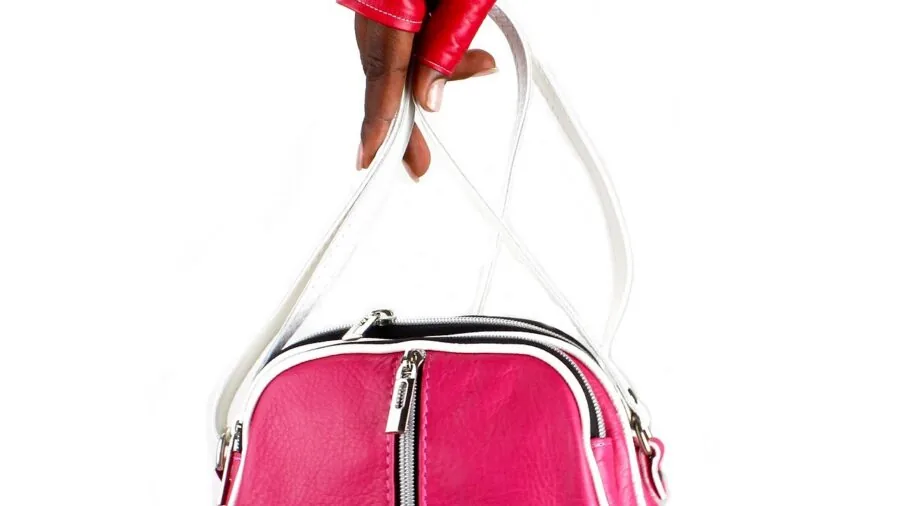 Woman holding canvas tote bag in hand while walking outdoors on sunny day