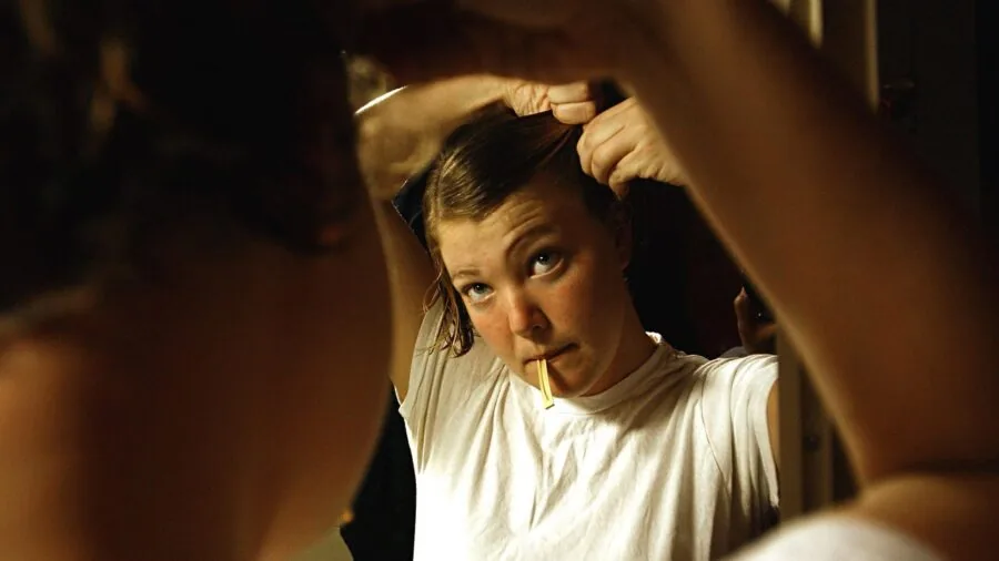 Woman in bathroom applying personal grooming products as part of self-care routine