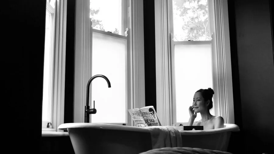 Woman in bathroom attending to personal hygiene and postpartum recovery care routine