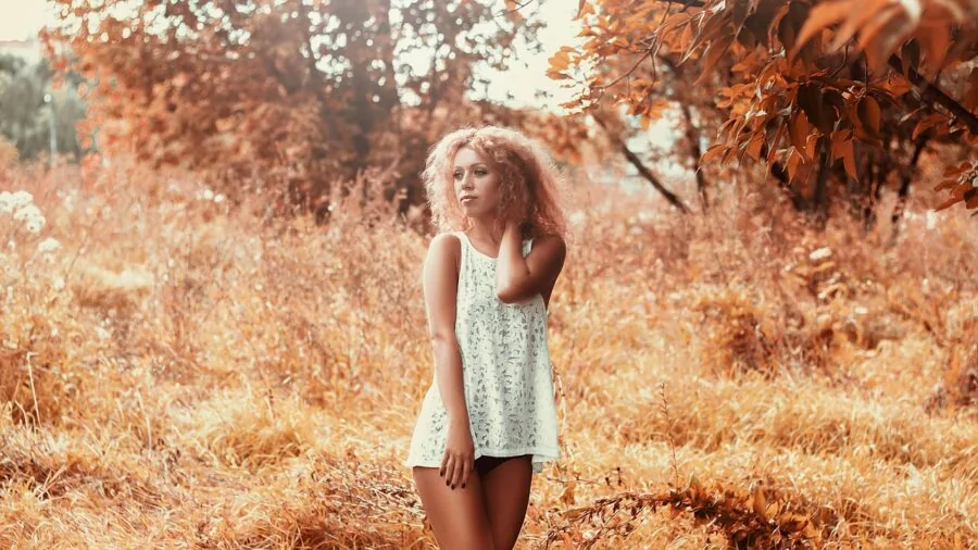 Woman in casual shorts checking pocket capacity while standing outdoors in natural daylight