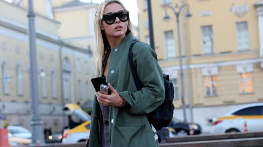 Woman in classic knee-length trench coat walking outdoors in elegant style