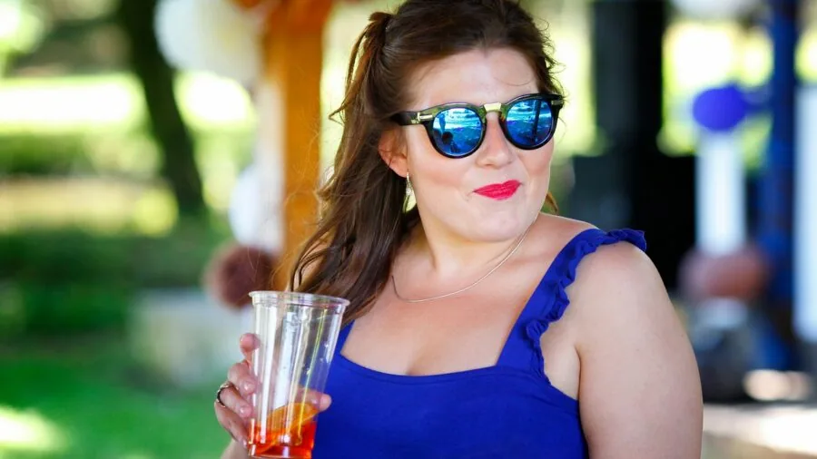 Woman in elegant midi-length dress at upscale cocktail venue with confidence and poise