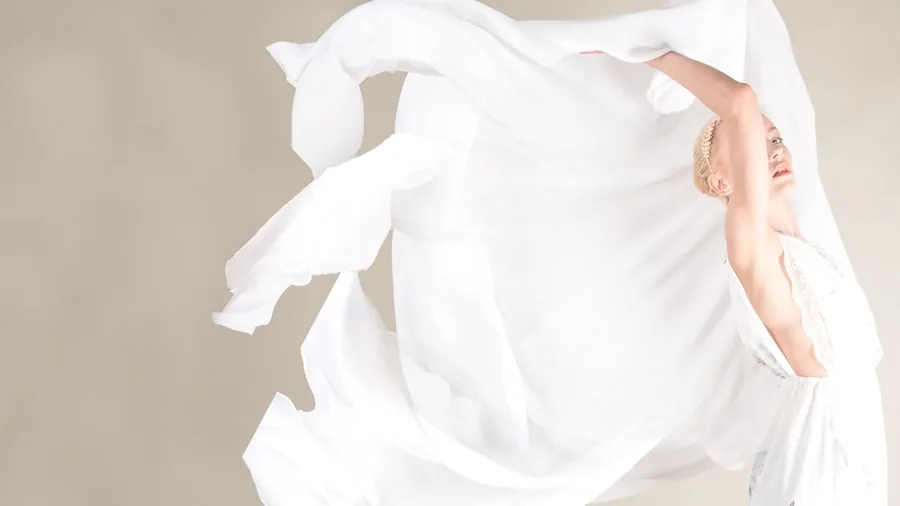 Woman in flowing dress fabric demonstrating quality drape and movement in natural lighting