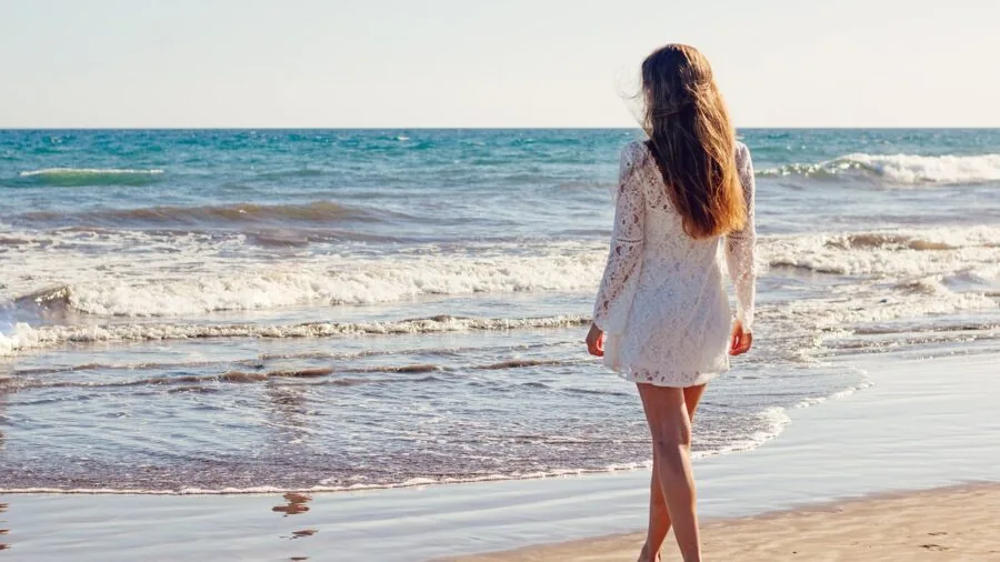 Woman in midi dress striding confidently outdoors, demonstrating elegant knee-to-ankle length styling