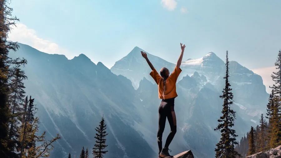 Woman in natural fiber base layers hiking on a mountain trail in cool weather