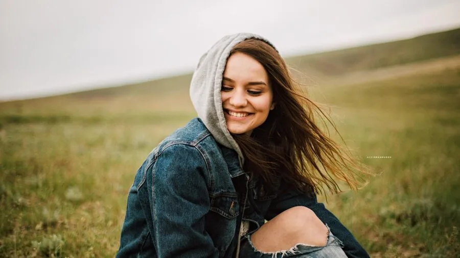 Woman in oversized hoodie relaxing outdoors, demonstrating comfortable fit style