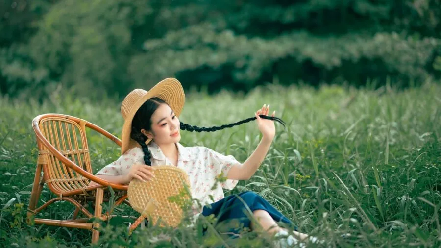 Woman in sleeveless summer dress enjoying outdoor sunlight in natural setting
