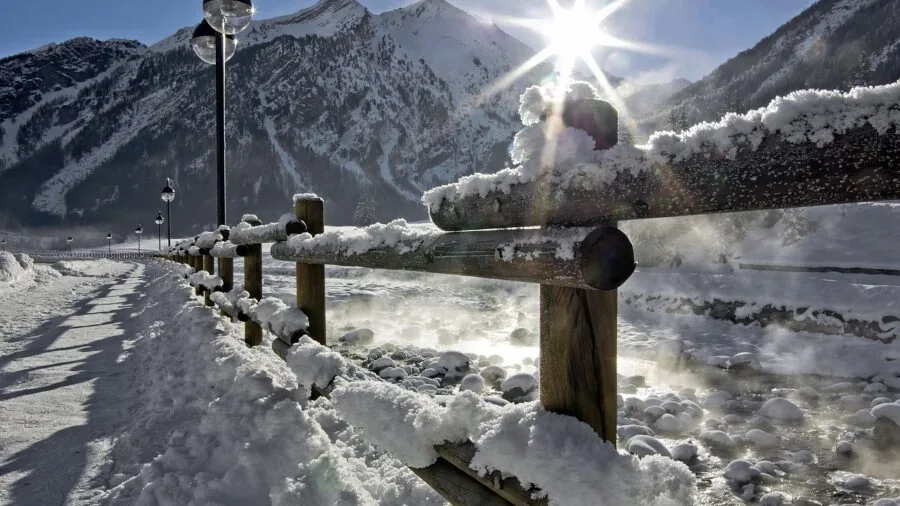 Woman in winter boots walking through snowy urban street during daytime