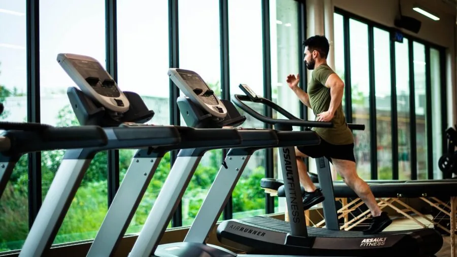Woman jogging on treadmill in home gym setup during workout session