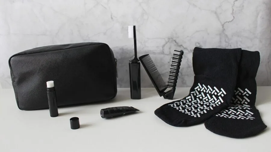 Woman organizing compact items in a toiletry bag for travel, demonstrating portability and packing efficiency