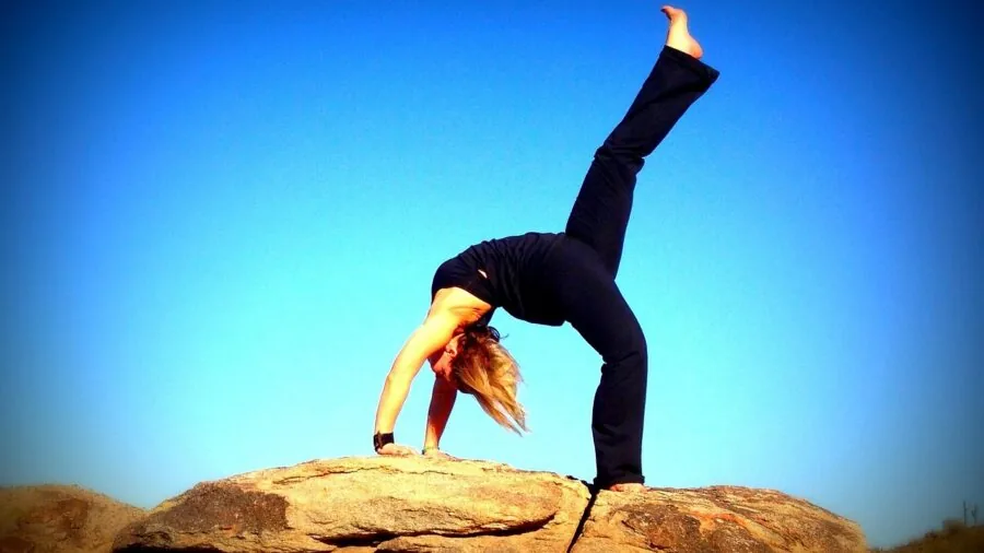 Woman performing supported backbend yoga pose on mat indoors