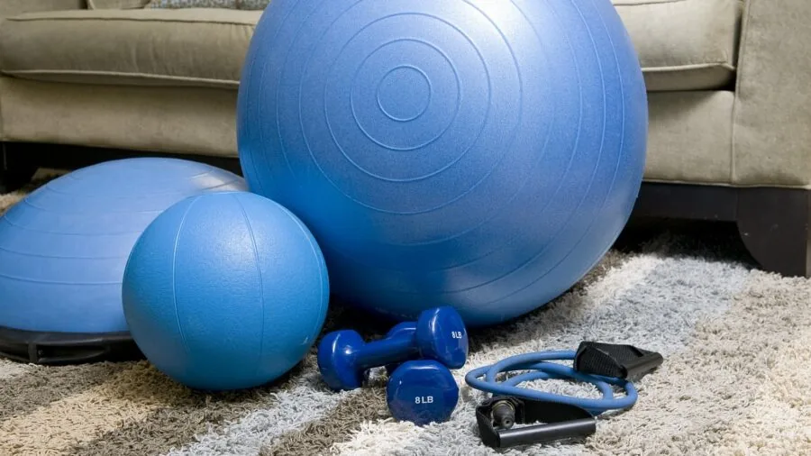 Woman performing upper body resistance band exercise during home fitness training session