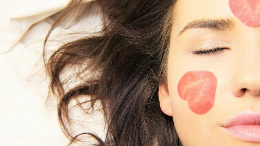 Woman receiving facial steam treatment with eyes closed, experiencing skincare benefits in natural light