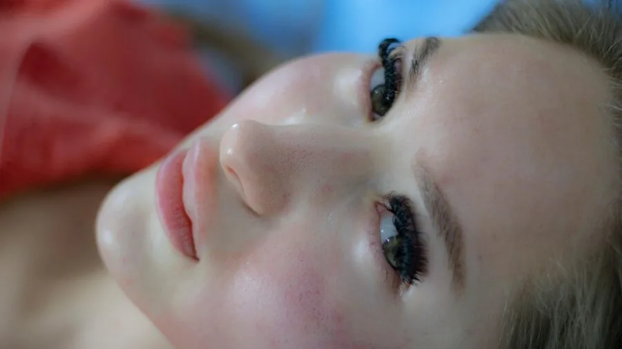 Woman refreshing her face with facial mist spray during skincare routine