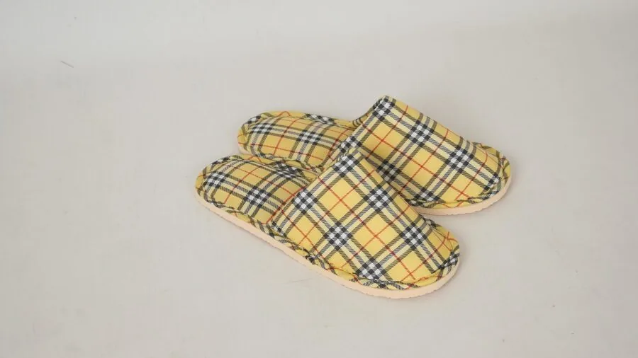 Woman relaxing indoors wearing soft comfortable slippers on hardwood floor at home