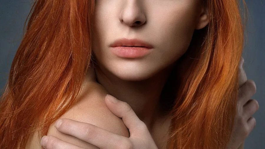 Woman running fingers through hair to check texture and condition