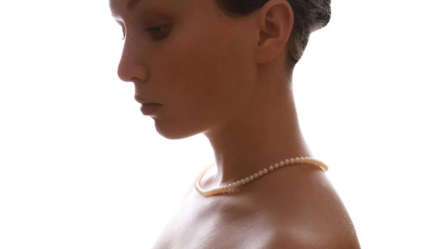 Woman styling pearl necklace with casual outfit for everyday wear