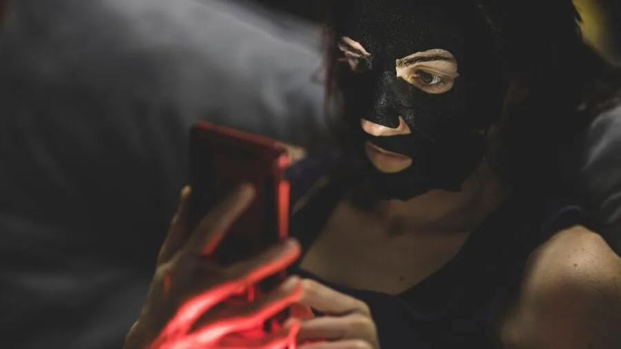 Woman thoughtfully comparing skincare products and prices while shopping for affordable beauty options