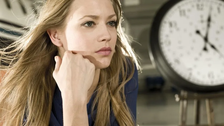 Woman thoughtfully considering clothing purchases while shopping, representing smart budget decisions for special occasions