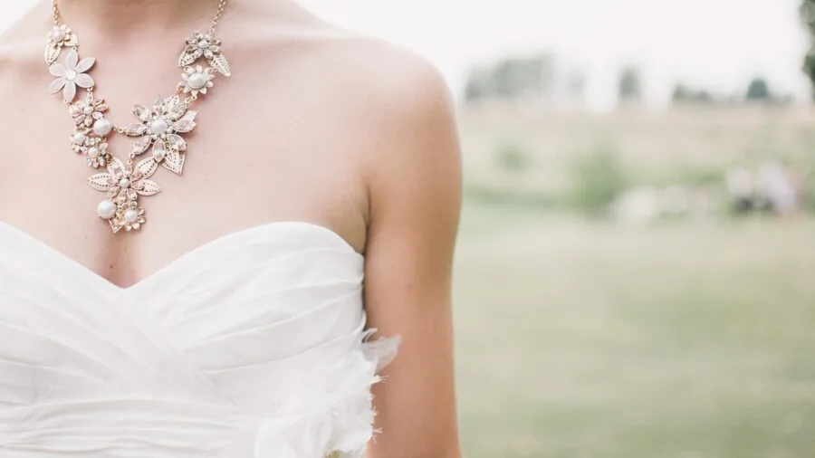 Woman thoughtfully examining affordable jewelry options while shopping, considering value and quality