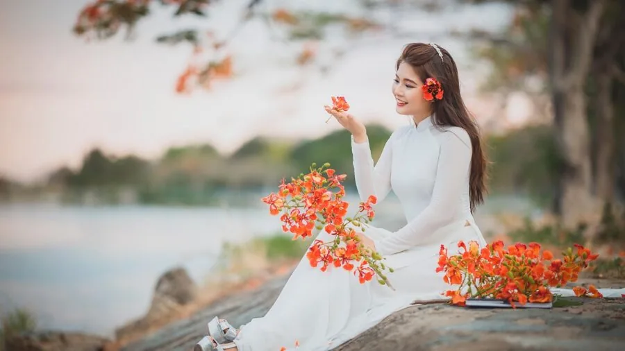 Woman thoughtfully selecting a dress from her closet, considering wardrobe versatility and reusability