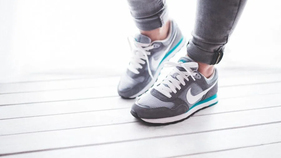 Woman walking on natural path wearing comfortable walking shoes, demonstrating proper footwear support