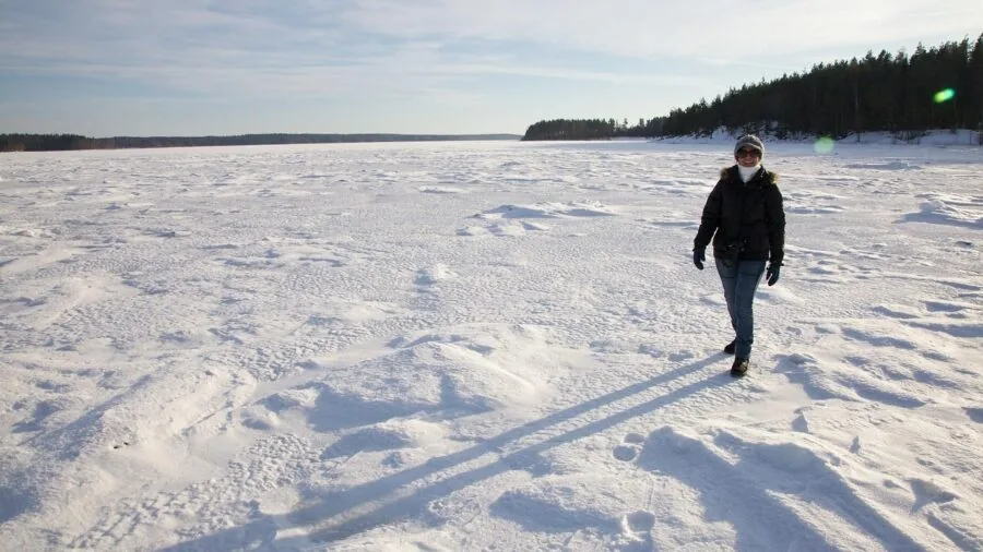 Woman walking outdoors in heavy snow and winter conditions wearing boots