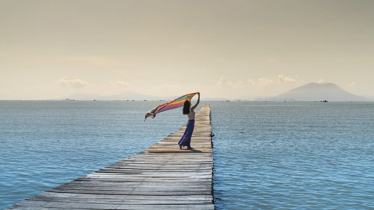 Woman wearing colorful backpack outdoors with natural scenery background