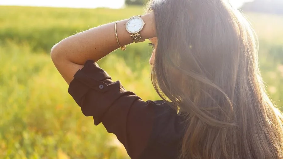 Woman wearing metal anklet in natural sunlight, showing jewelry detail on skin during outdoor activity