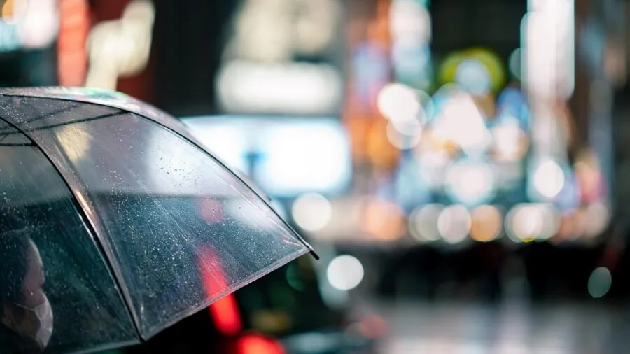 Woman wearing puffer jacket in light rain outdoors