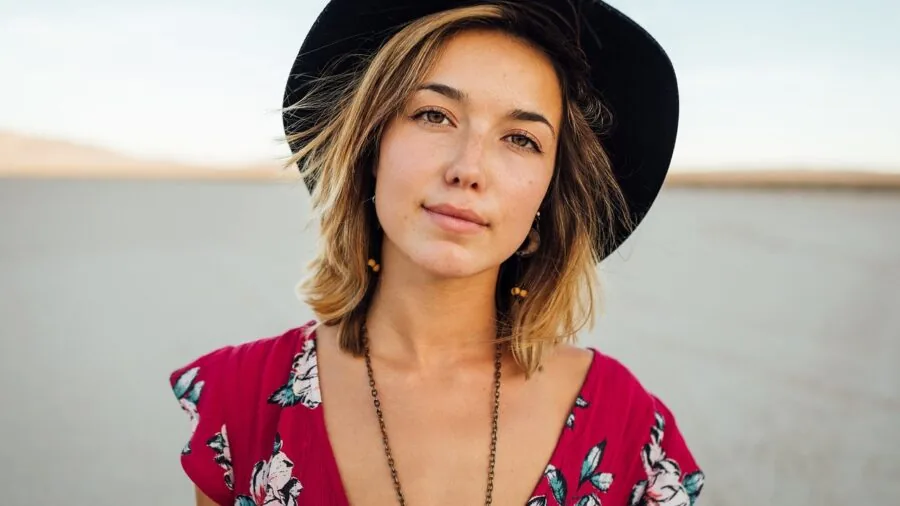 Woman wearing versatile beach-to-dinner outfit walking along sandy shore at golden hour