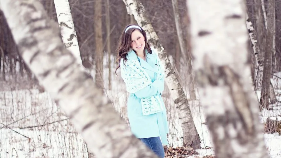 Woman wearing winter coat in snowy rainy weather, demonstrating waterproof fabric performance outdoors
