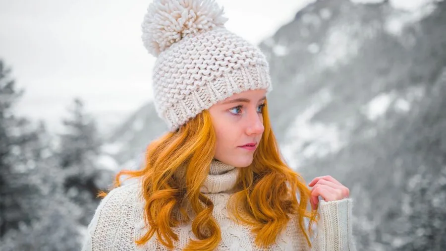 Woman wearing winter coat with hood in snowy weather, adjustable hood covering hat for protection