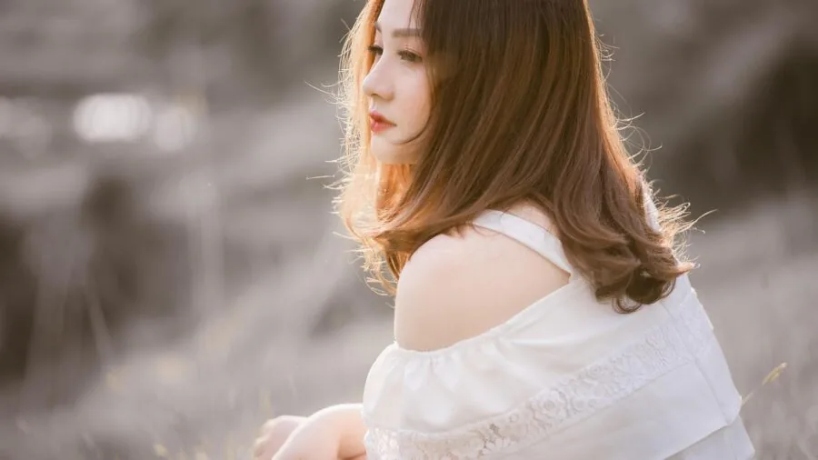 Woman with bright colored hair in natural sunlight, showcasing healthy color vibrancy and shine