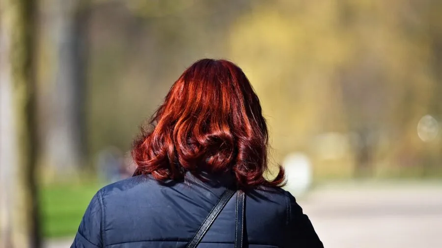 Woman with glossy, voluminous hair displaying shine and smoothness from professional hair care