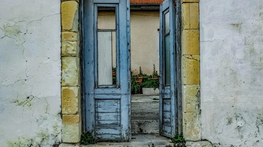 Wooden door entrance with rain droplets and weathered finish showing exposure to outdoor elements