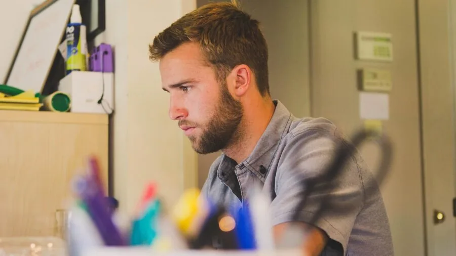 Worker adjusting standing desk to proper ergonomic height for comfortable workspace