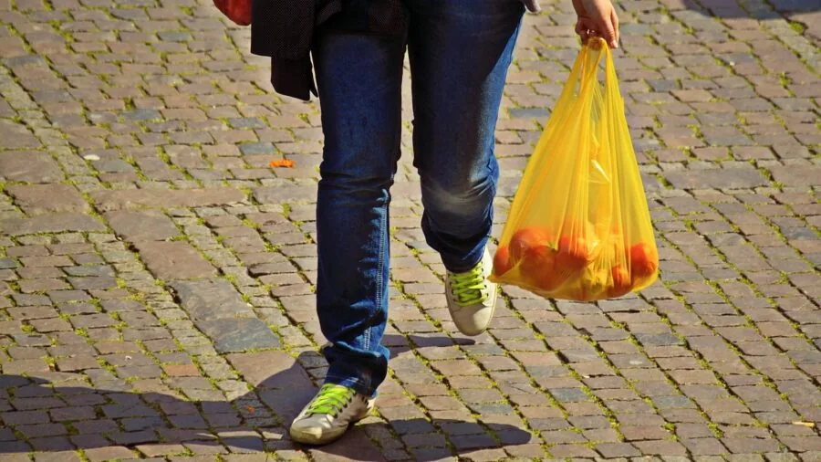 Worker carrying padded tote bag over shoulder while walking, demonstrating ergonomic comfort and proper weight distribution