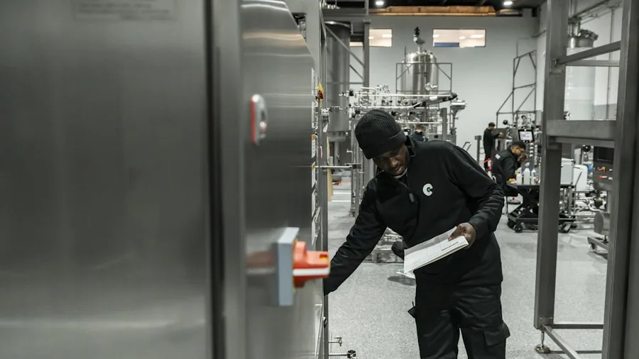 Worker checking equipment display in shadowy mechanical room with ladder