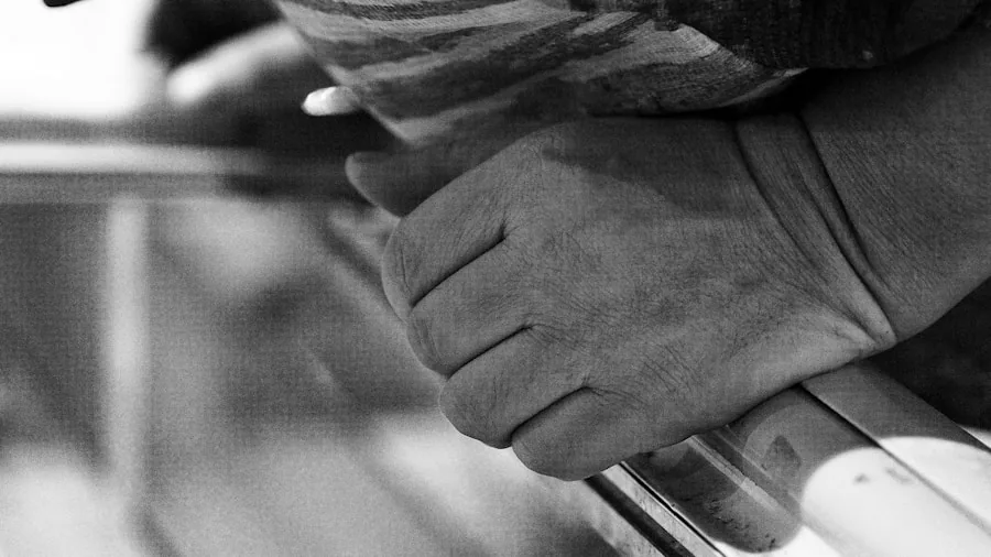 Worker's hands firmly gripping a tool against textured work surface