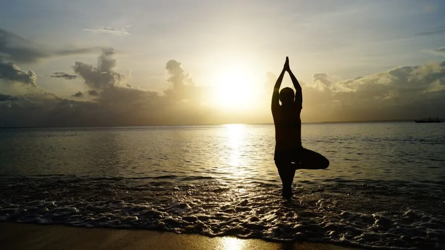 Yoga practitioner using a towel during a fitness session on a mat indoors