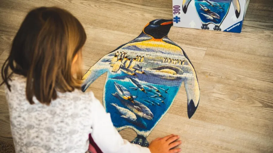 Young child concentrating on solving a puzzle, demonstrating age-appropriate cognitive challenge and engagement