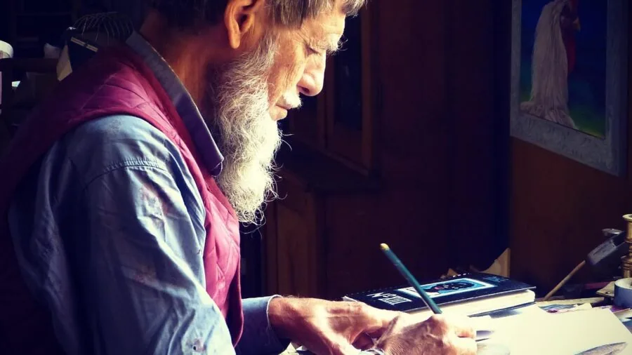 Young child concentrating while working on a hands-on creative craft project at a table