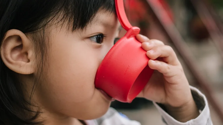 Young child drinking from a cup during mealtime, demonstrating safe hydration practices for toddlers