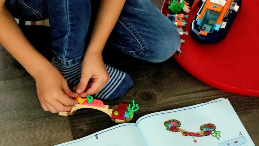 Young child engaged in hands-on building activity with construction blocks at home