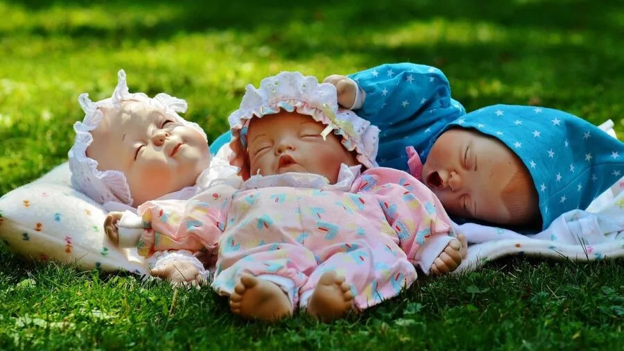 Young child engaged in imaginative play holding a lifelike baby doll indoors