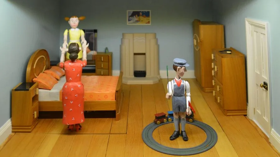 Young child engaged in imaginative play with wooden dollhouse, examining details and materials